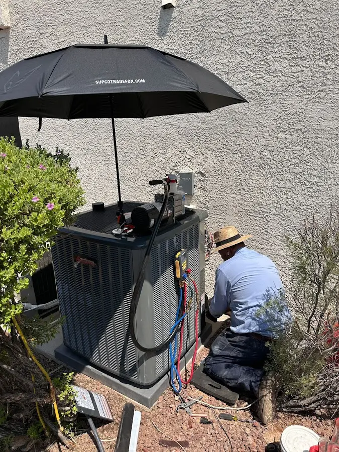 HVAC technician performing outdoor AC maintenance in Guthrie