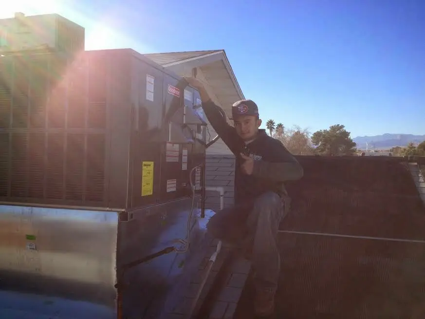 HVAC technician performing Heat Pump Repair on a rooftop unit in Guthrie